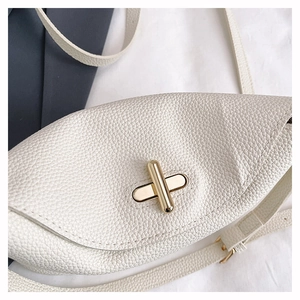 Close-up of white pebble grain leather chest bag with golden cross twist-lock buckle