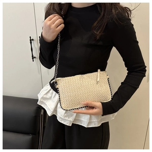 Detailansicht der beigen geflochtenen Umschlagtasche mit Silberperlen und feiner Kette