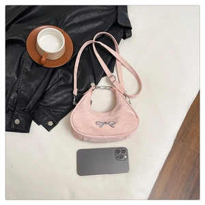 Pink crescent underarm bag with silver bow accent and metallic chain handle detail