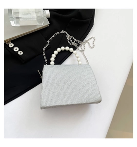 Detailed view of silver glitter clutch with pearl handle and metal chain strap