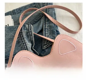 Detailed view of pink cat-ear handbag featuring an anime character and embroidery