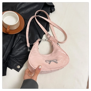 Close-up of pink crescent handbag with marble texture fabric and silver bow detail