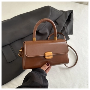 Detail of vintage brown PU leather handbag featuring a polished gold rectangular buckle
