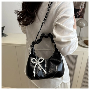 Détail du sac nuage noir avec nœud en perles et bandoulière en chaîne argentée élégante
