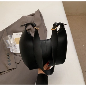 Detail of black matte leather crescent bag with golden buckle and wide shoulder strap