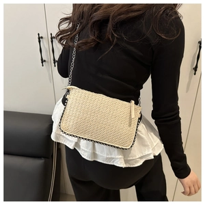Detailansicht beige Web-Umhängetasche mit schwarzem Perlenrand und silberner Kette