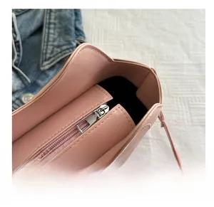 Detailed close-up of the smooth silver zipper closure on a pink leather shoulder bag