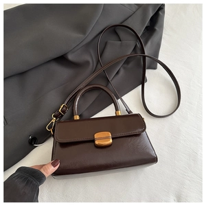 Detail view of dark brown vintage faux leather handbag with matte gold clasp and handle