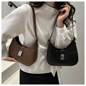 Detail of minimalist leather shoulder bag with S-shaped silver metal buckle and strap