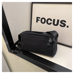 Detail of lightweight black waterproof nylon crossbody bag with multiple zipper pockets