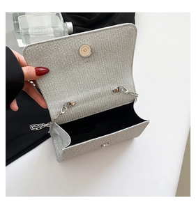 Macro shot of silver shimmer evening clutch bag interior with metal chain and magnetic snap