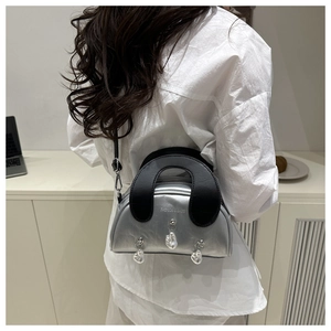 Silver shell-shaped handbag with pearl chain pendants shown on a model's back