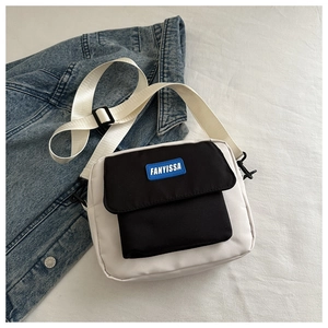 Détail d'un sac bandoulière minimaliste noir et blanc avec logo FANYISSA