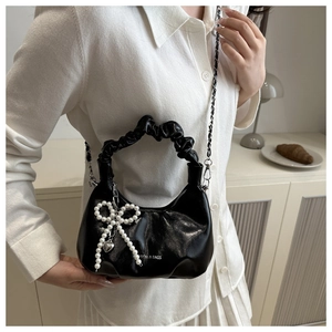 Détail du sac bandoulière noir brillant plissé avec pendentif perle et chaîne argent