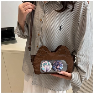 Detailed view of brown cat-ear ita bag with transparent window and anime badges