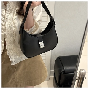 Close-up of matte black saddle bag featuring a minimalist silver square buckle detail