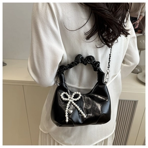 Detail of black crescent bag with pearl bow heart pendant and cloud ruched handle