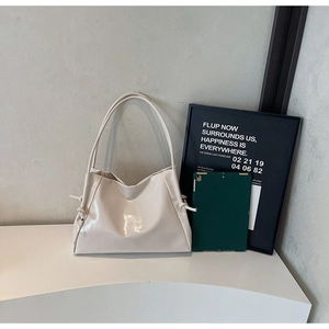 Detail of cream white tote bag with side knot accents and sleek minimalist design