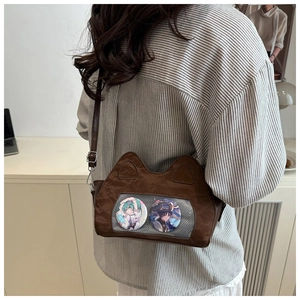 Detail view of brown cat ear ita-bag featuring transparent display window with anime badges