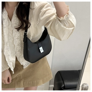 Model wearing a black crescent hobo bag with silver buckle and adjustable shoulder strap