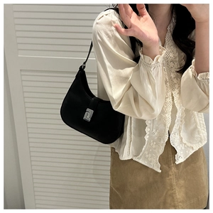 Detail of a chic black leather crescent hobo bag with a silver buckle on the shoulder