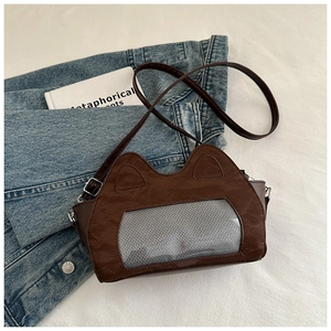 Detail of a brown cat-eared crossbody bag with a mesh window and adjustable strap