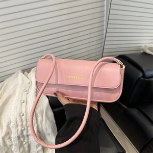 Minimalist pink leather shoulder bag with a rectangular flap design and gold lettering