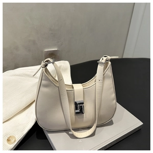 Close-up of cream-white crescent shoulder bag with silver ring buckle detail and smooth leather