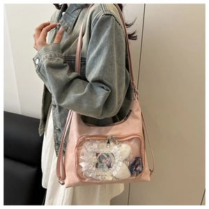 Detailed view of pink itabag showing clear PVC window with lace trim and badges