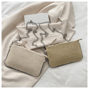 Details der gewebten Strohketten-Taschen in Beige und Hellbraun mit Metallperlen