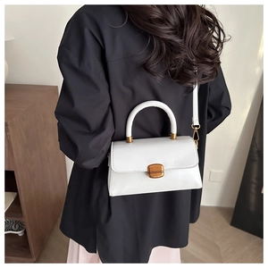 Lifestyle view of white vintage square crossbody bag with gold buckle on blue shirt