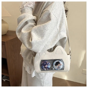 Detailed view of an off-white cat-ear ita bag featuring a clear PVC window for pin display