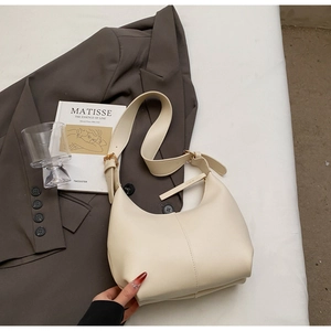 Detail view of cream hobo bag with gold adjustable buckle and structured stitching