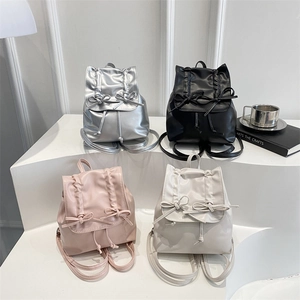 Sweet mini backpacks in silver, black, pink and cream with bow details on white pedestal
