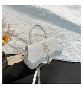 Silver glitter flap handbag with wavy bottom edge and metallic tassel detail