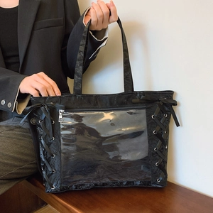 Detail of black ribbon ITA bag with transparent window and bow accents for plush display