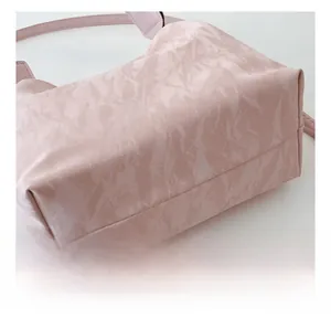 Detail showing pleated texture and precise stitching on a pale pink bucket bag