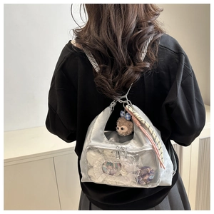 Detail of silver metallic ita bag showing transparent window for anime badges and plushies