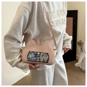 Detailed view of pink cat-ear ita bag featuring a clear window with anime badges and straps