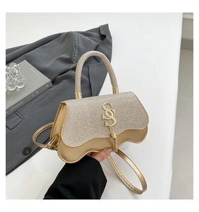 Champagne gold glitter crossbody bag with wave edge lid and metallic tassel detail