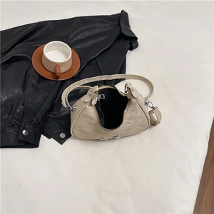 Chic beige bow crescent shoulder bag with pleated texture and silver metal hardware