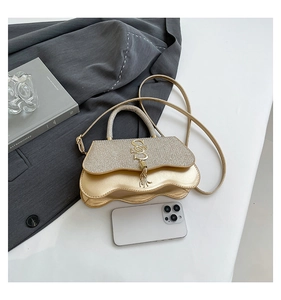 Champagne gold crossbody bag with glitter flap and phone for scale reference