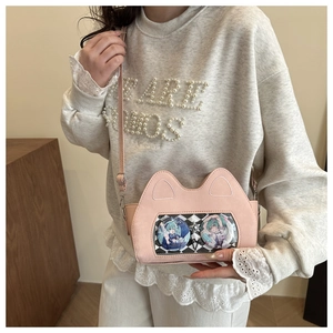 Detail of pink cat-ear ita bag with transparent PVC window showing anime badges