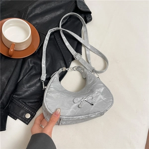 Silver metallic bow crescent hobo bag with textured leather and adjustable strap