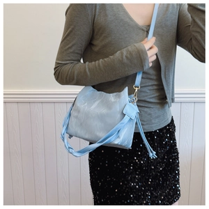 Detail of light blue bucket bag with cat-ear shape and marble texture on model
