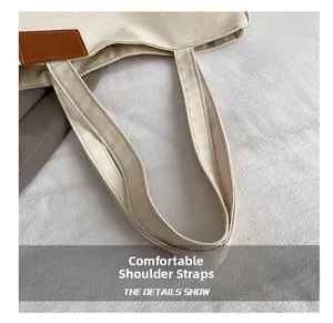 Détail du sac cabas en toile blanc cassé avec coutures renforcées et patch en cuir