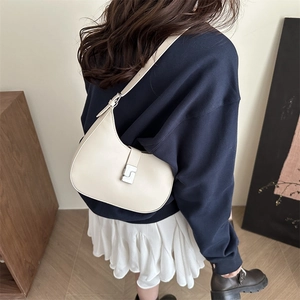 Chic cream crescent shoulder bag with silver buckle worn by model in a daily setting