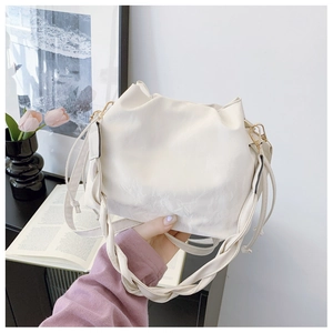 Detailed close-up of cream PU leather bucket bag with pleated drawstring and woven strap