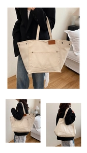 Détail d'un sac cabas en toile avec garnitures en cuir marron et rivets métalliques