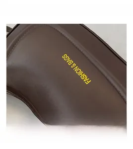 Detail of dark brown leather crescent bag with yellow Fashion & Bags printed text